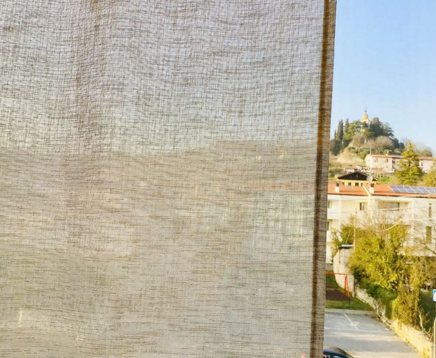 Dettaglio che evidenzia la trasparenza del tessuto colore lino effetto lino, con luce che filtra delicatamente attraverso la trama.