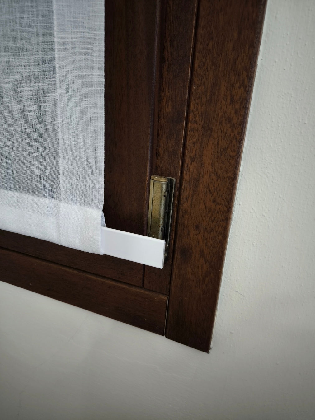 Parte inferiore di una tenda con una tasca cucita che contiene una piattina in alluminio, utilizzata per mantenere la tenda ben tesa