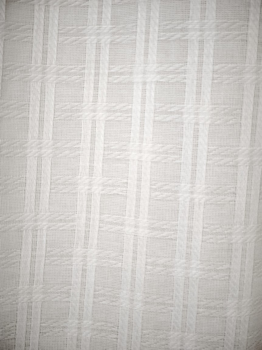 Dettaglio del tessuto jacquard bianco con lavorazione in rilievo