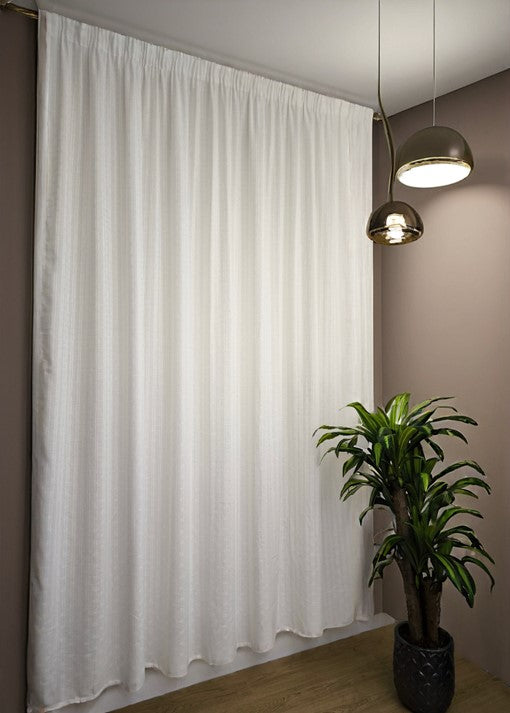 Tenda bianca jacquard appesa al binario con fettuccia arricciatenda