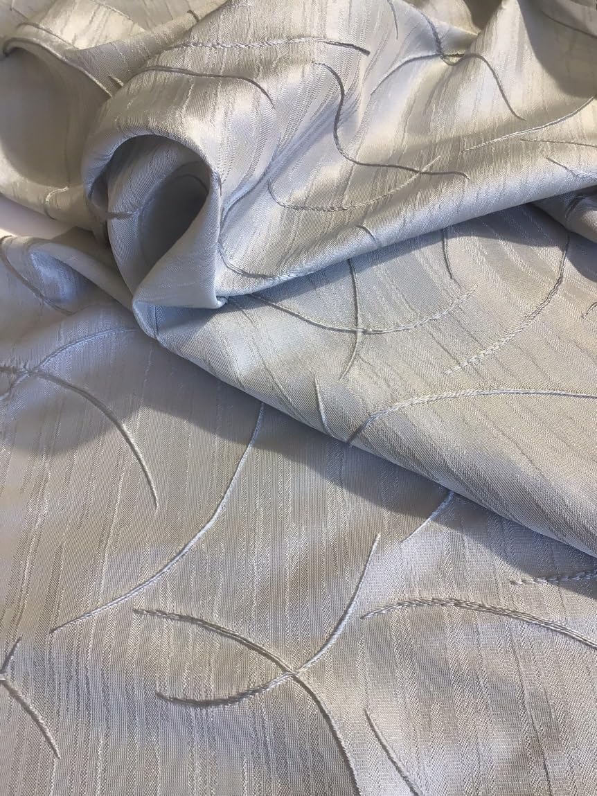 Dettaglio ricamo geometrico della tenda grigia su misura con fettuccia arricciatenda.