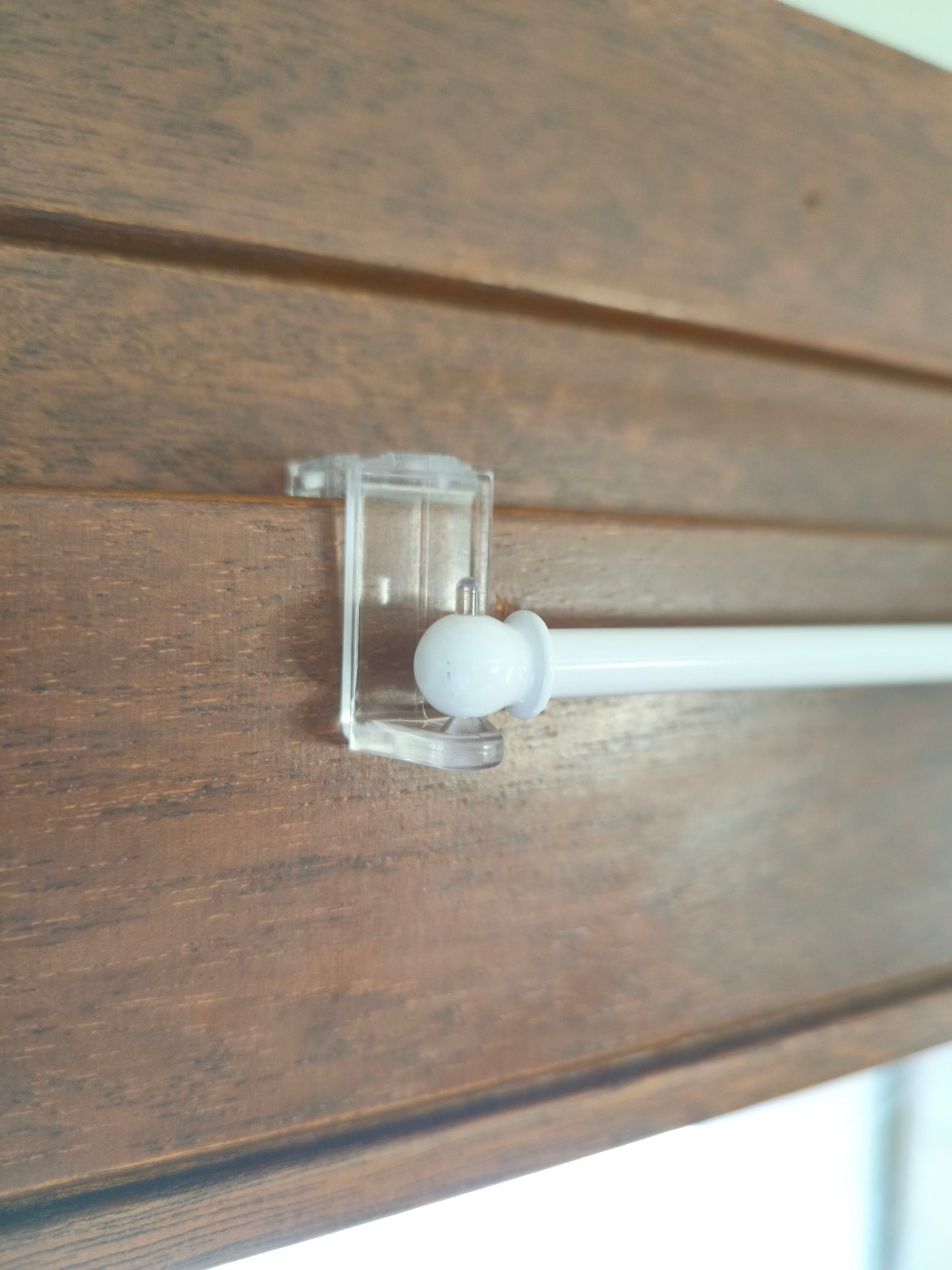 Bastoncino per tende installato con supporto regolabile su finestra in legno