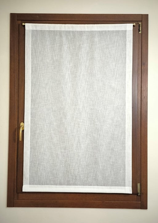 Tenda a vetro bianca effetto lino appesa con bastoncino a una finestra – prodotto finito installato